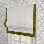 Flat Roman shade with green border and white fabric, installed on a window with geometric wallpaper. Customizable and easy to install.