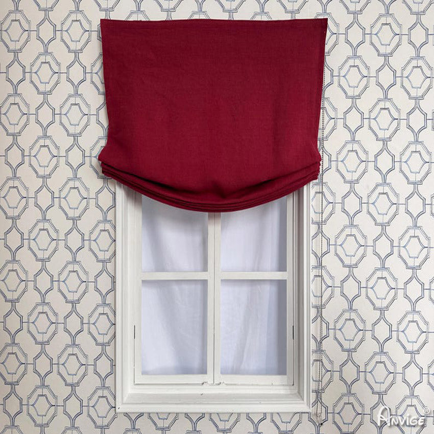 Anvige Relax Roman Shades in deep red fabric, partially folded, installed on a window with geometric wallpaper background. Customizable for privacy and style.