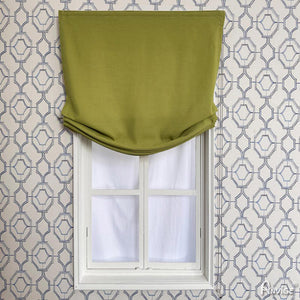 Green custom Roman shade in relaxed style, mounted on a white-framed window with geometric wallpaper background. Anvige Style 751 ZY.