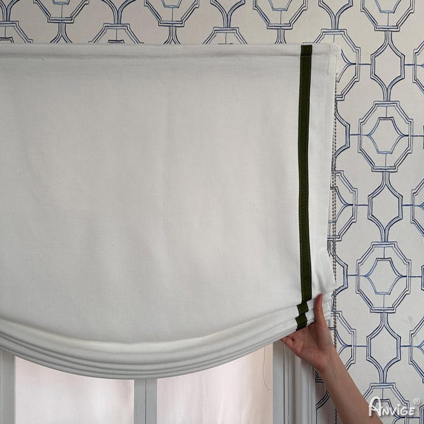 Close-up of Anvige Roman Shades being adjusted, showcasing white fabric with green trim and light-filtering design. Easy to install and customizable.