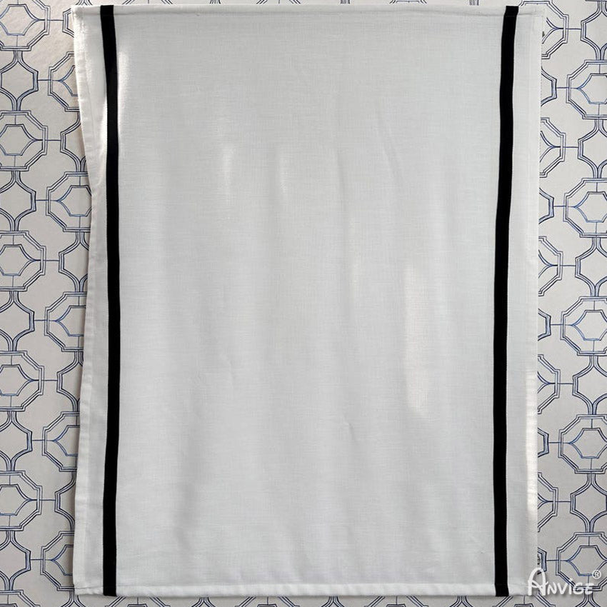 Flat Anvige Relax Roman Shade in white with black trim, displayed against geometric wallpaper. Ideal for custom window treatments.