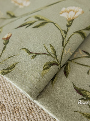 Detailed view of folded Roman shade fabric with green leaves and white flowers, showcasing its high-quality material and craftsmanship.