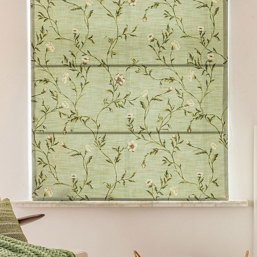 Custom Roman shade with printed green leaves and flowers, fully extended on a window, enhancing home decor with a natural theme.