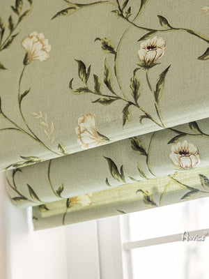 Close-up of Anvige Roman shade fabric featuring delicate green leaves and white flowers, highlighting the intricate printed design.